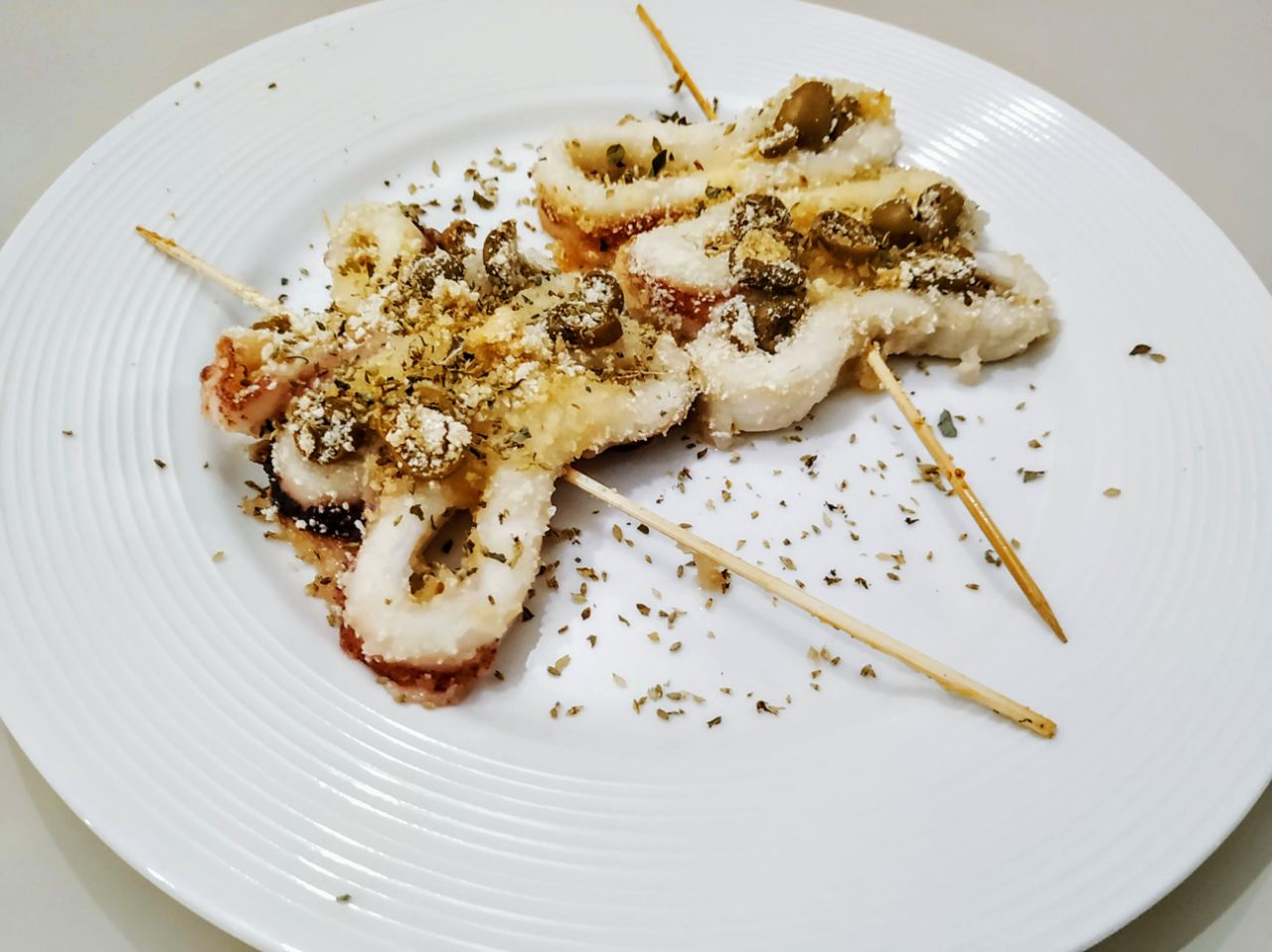 Antipasti a base di pesce: spiedini di anelli di calamaro con pane grattugiato e olive verdi!