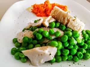 Secondi piatti semplici e leggeri a base di pesce: merluzzo con piselli verdi e insalata di carote con zenzero limone e olio evo