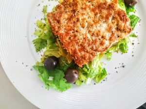 Secondi piatti a base di pesce: fish burger di merluzzo alle erbe aromatiche con insalata di sedano e olive greche condite