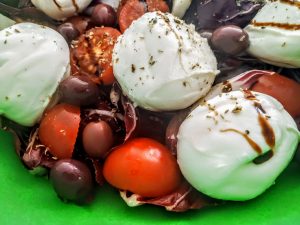 Ricette semplici veloci ed economiche: insalata di radicchio Rosso pomodorini olive nere e bocconcini di bufala con olio evo e aceto balsamico rosé