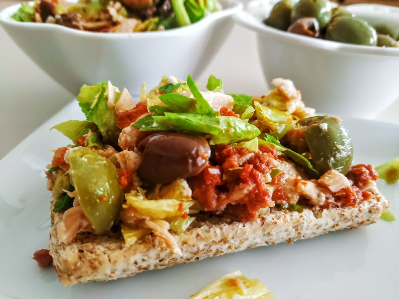 Antipasti stuzzicanti e veloci: crostoni integrali con insalata di salmone affumicato olive e pomodori secchi
