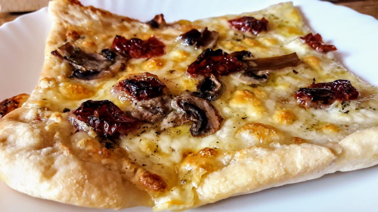 Ricette facili semplici e gustose: pizza di kamut bianca con impasto a lunga lievitazione farcita con mozzarella funghi champignon e pomodori secchi