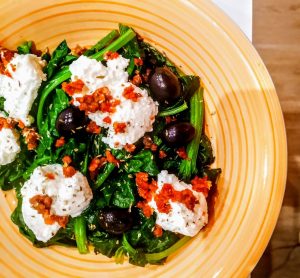 Secondi piatti vegetariani senza uova e senza burro: spinaci saltati in padella con pomodori secchi olive nere e ricotta di bufala