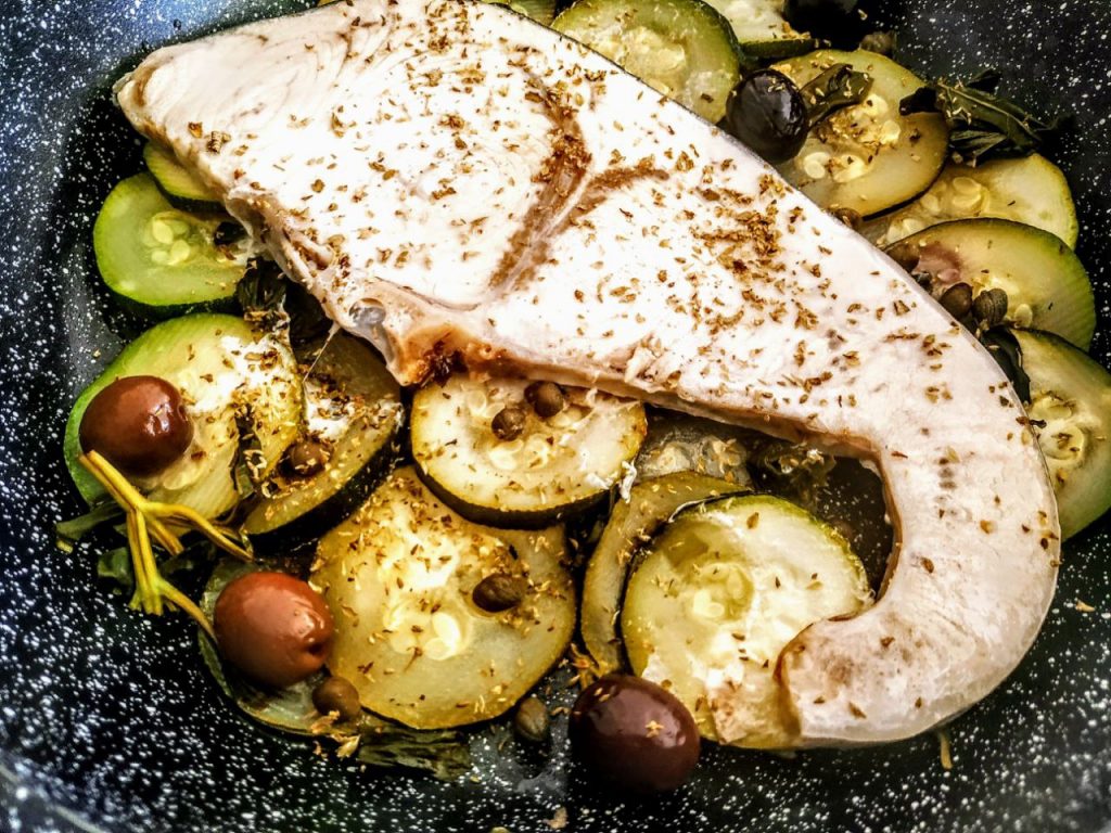 Secondi piatti a base di pesce semplici e veloci: filetti di pesce spada con zucchine capperi olive nere e olio evo