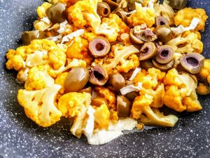 Ricette economiche a base di verdure senza uova e senza burro: cavolfiore arancione con olive verdi e formaggio cremoso