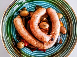 Secondi piatti a base di carne senza burro e senza lattosio: salsiccia di pollo con peperoni zucchine e olive