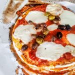 Piadipizza con mozzarella pomodoro pelati e olive denocciolate