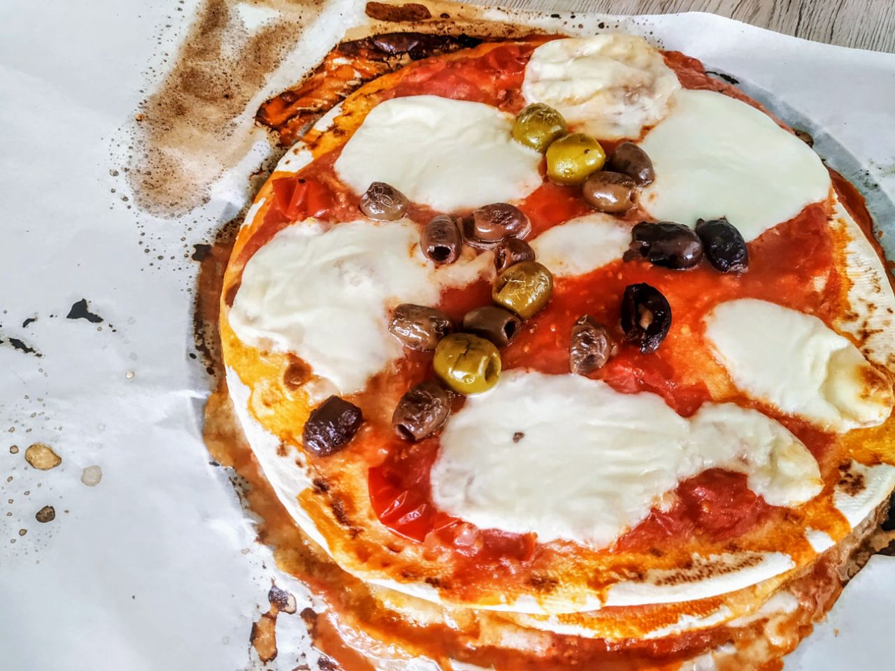Piadipizza con mozzarella pomodoro pelati e olive denocciolate